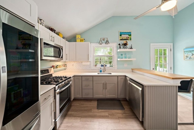 11 Brunswick St, Marshfield, MA 02050 - kitchen with stainless steel appliances, a peninsula, a sink, lofted ceiling, and light countertops