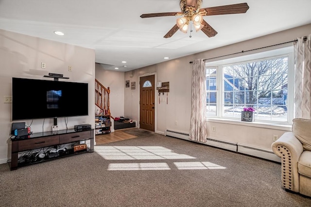 living room featuring baseboard heating, ceiling fan, and light colored carpet