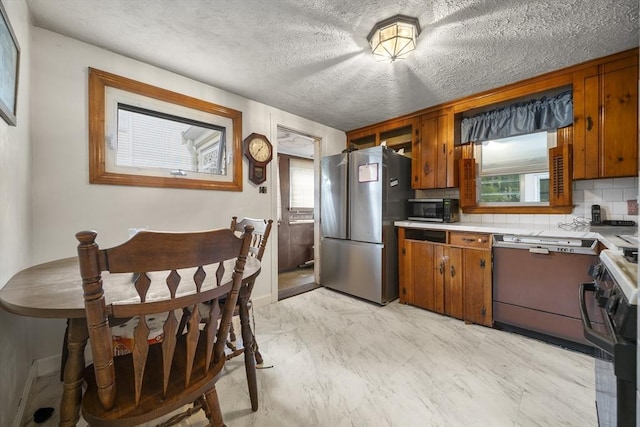 5 Cranmore, Boston, MA 02136 - kitchen with stainless steel appliances, light countertops, brown cabinetry, tasteful backsplash, and a textured ceiling