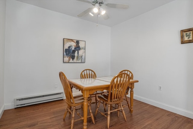 dining space with dark hardwood / wood-style floors, baseboard heating, and ceiling fan