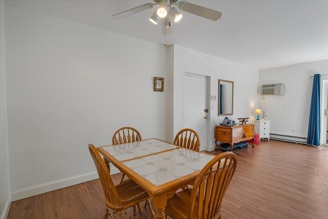 dining area with wood-type flooring, an AC wall unit, baseboard heating, and ceiling fan