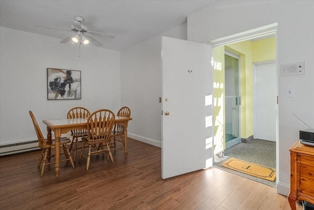 dining area featuring ceiling fan, dark wood-type flooring, and a baseboard radiator