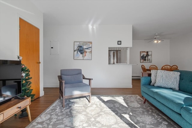 living room with ceiling fan, wood-type flooring, electric panel, and a baseboard radiator