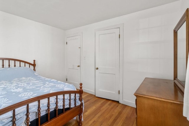 bedroom featuring baseboards and light wood finished floors