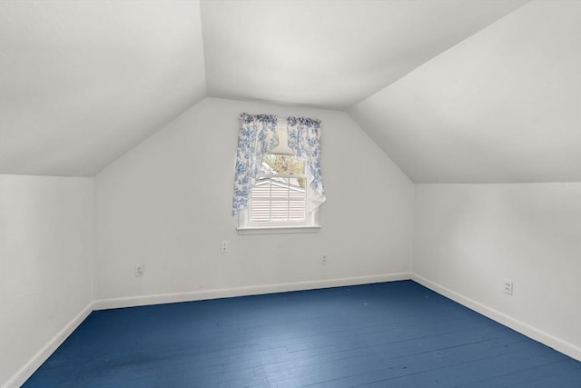 additional living space with baseboards, hardwood / wood-style flooring, and lofted ceiling