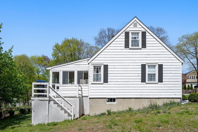 back of property with a sunroom and stairway