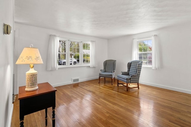 sitting room featuring baseboards, wood-type flooring, and visible vents