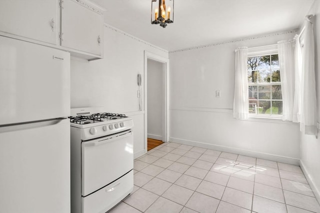 kitchen with white cabinets, light tile patterned flooring, a notable chandelier, white appliances, and baseboards
