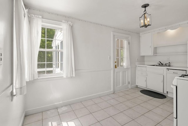 kitchen featuring a sink, baseboards, white cabinetry, and light countertops