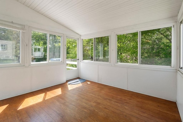 unfurnished sunroom featuring wood finished floors, a wooden deck, and lofted ceiling