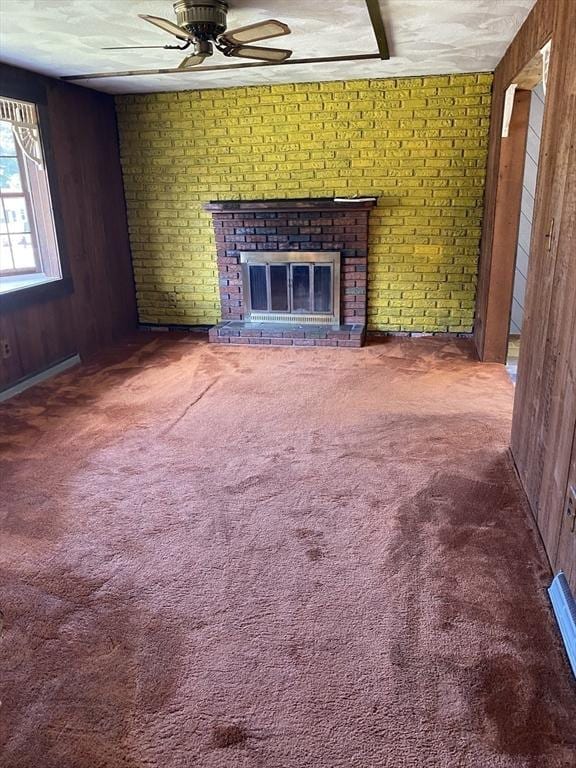 62 Duncan Rd, Stoughton, MA 02072 - unfurnished living room with ceiling fan, wooden walls, a brick fireplace, and carpet floors