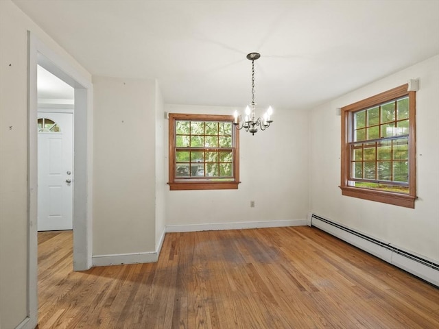 51 Quaboag Rd, Acton, MA 01720 - unfurnished dining area with a baseboard radiator, wood finished floors, a chandelier, and plenty of natural light