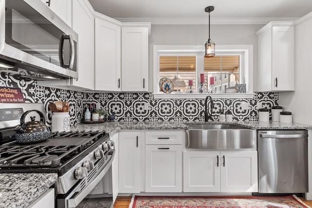 57 Railroad Ave Unit C1, Salisbury, MA 01952 - kitchen with appliances with stainless steel finishes, white cabinetry, decorative light fixtures, backsplash, and crown molding