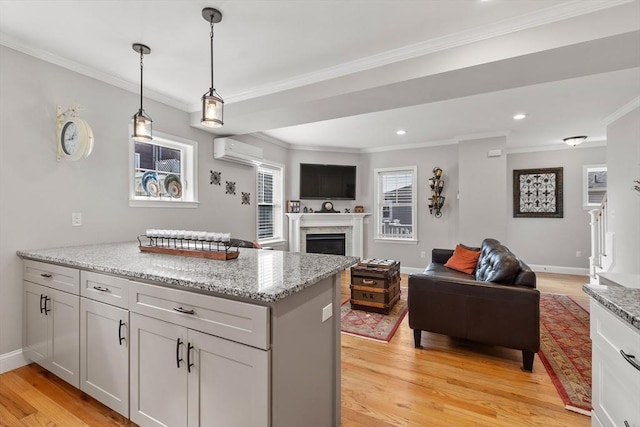 57 Railroad Ave Unit C1, Salisbury, MA 01952 - kitchen featuring open floor plan, a wall mounted air conditioner, crown molding, light wood-style floors, and a fireplace