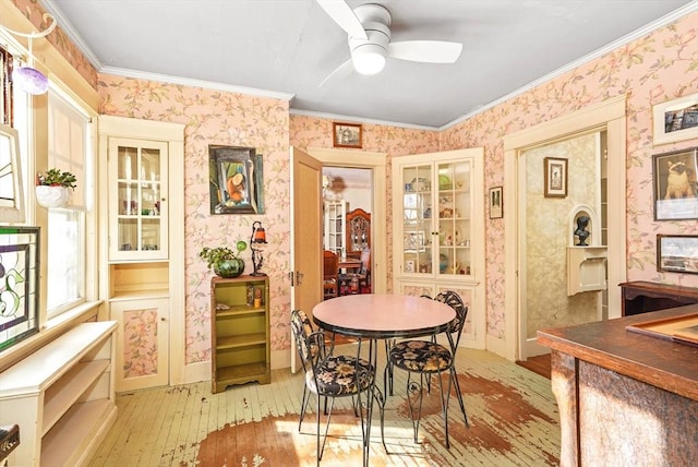 dining area with crown molding, ceiling fan, and light wood-type flooring