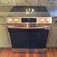 details featuring stainless steel electric range oven, light countertops, and wood finished floors