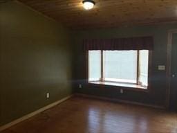 empty room with wood ceiling and baseboards