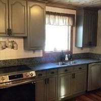 kitchen featuring decorative backsplash, dark countertops, oven, stainless steel dishwasher, and a sink