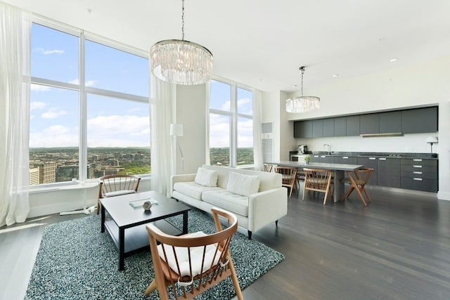 living room featuring sink, dark hardwood / wood-style floors, and an inviting chandelier