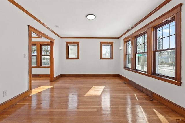 unfurnished room featuring light wood-style floors, baseboards, and ornamental molding