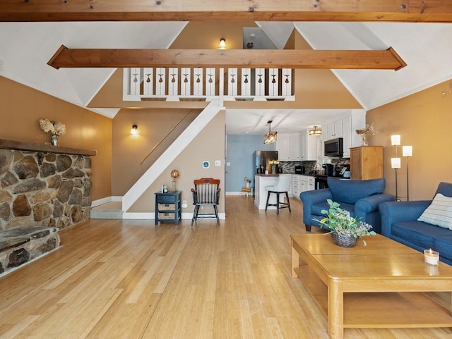 11 Grove Point Rd, Wales, MA 01081 - living room featuring high vaulted ceiling, light wood finished floors, beam ceiling, baseboards, and stairway