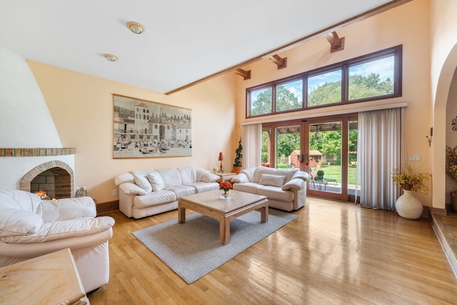 living room featuring a fireplace, a high ceiling, and light wood-type flooring