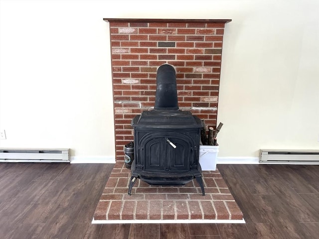 room details featuring a wood stove, baseboards, a baseboard heating unit, and wood finished floors