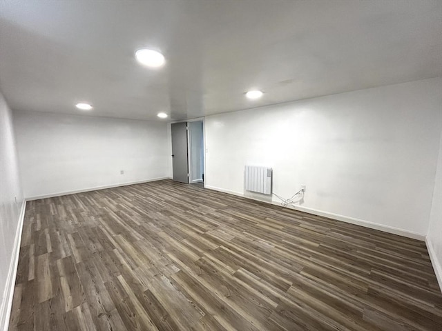 interior space featuring dark wood-style floors, radiator heating unit, baseboards, and recessed lighting