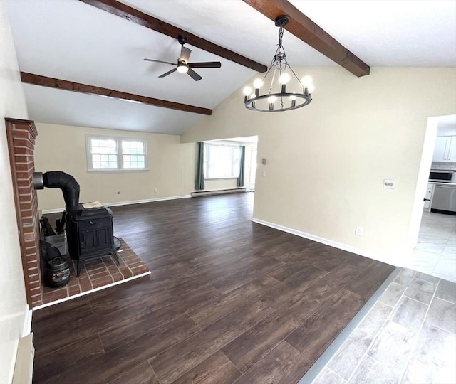 unfurnished living room with vaulted ceiling with beams, ceiling fan with notable chandelier, wood finished floors, baseboards, and a wood stove