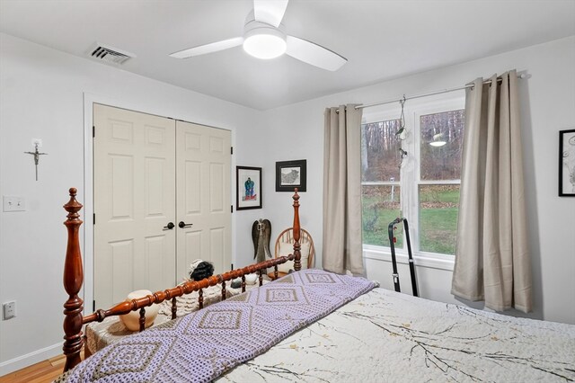 bedroom featuring ceiling fan, wood-type flooring, and a closet