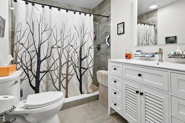 bathroom featuring tile patterned floors, vanity, toilet, and curtained shower