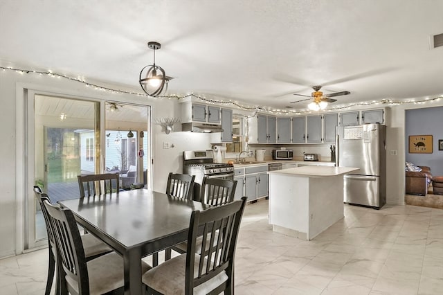 dining space with ceiling fan and sink