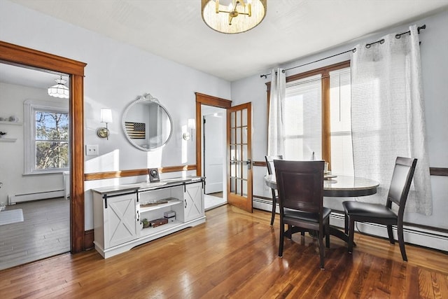 dining area with french doors, dark hardwood / wood-style floors, a baseboard radiator, and a notable chandelier