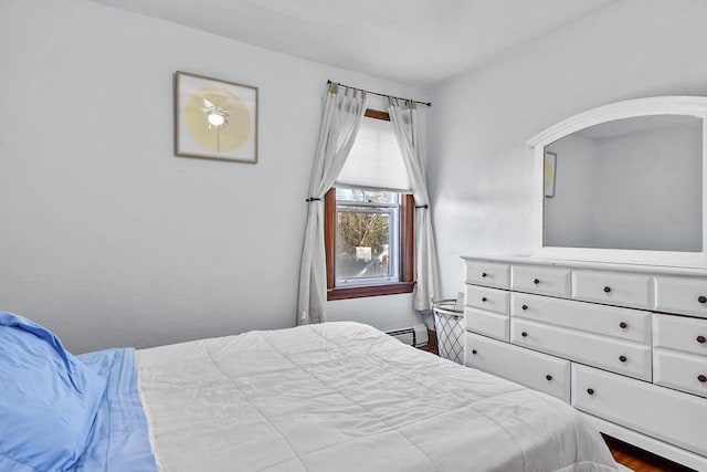 bedroom with baseboard heating and hardwood / wood-style floors