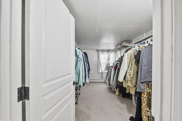 spacious closet with light carpet and a baseboard heating unit