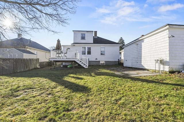 rear view of property with a wooden deck, a patio area, and a yard