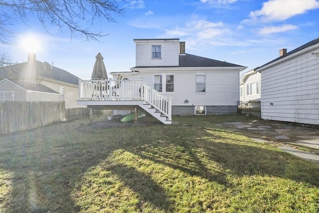 back of house featuring a wooden deck and a yard