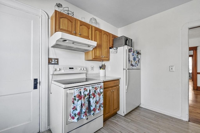 kitchen with light hardwood / wood-style floors and white appliances