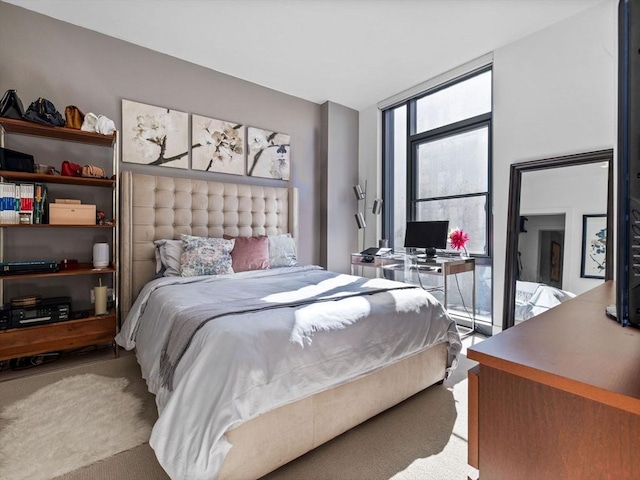 carpeted bedroom with a wall of windows