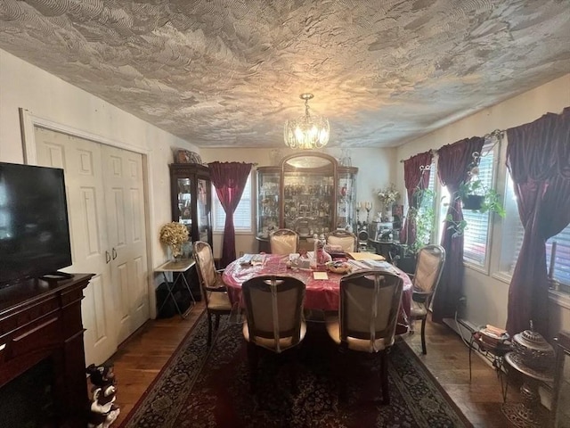 dining room featuring a notable chandelier, a textured ceiling, and hardwood / wood-style flooring