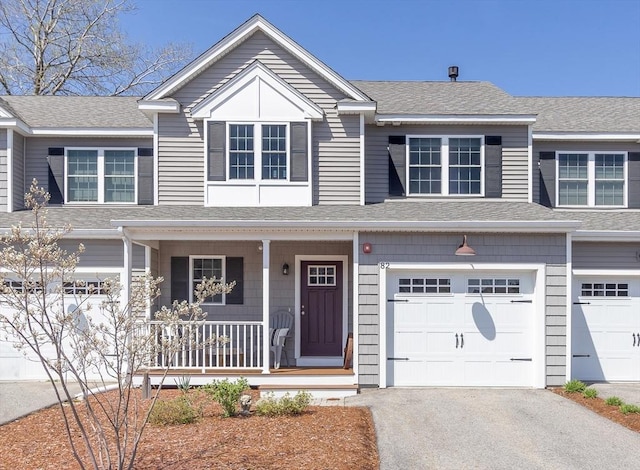 view of front of house featuring a shingled roof, an attached garage, a porch, and aphalt driveway