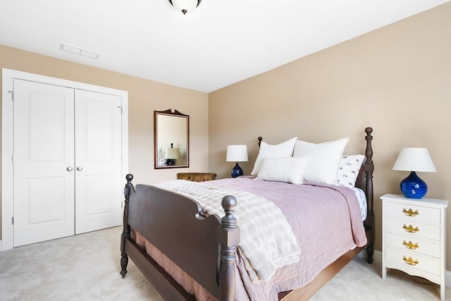 bedroom featuring visible vents, a closet, and light colored carpet