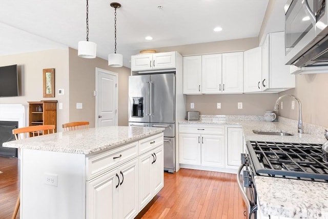 kitchen with stainless steel appliances, recessed lighting, a sink, and light wood-type flooring