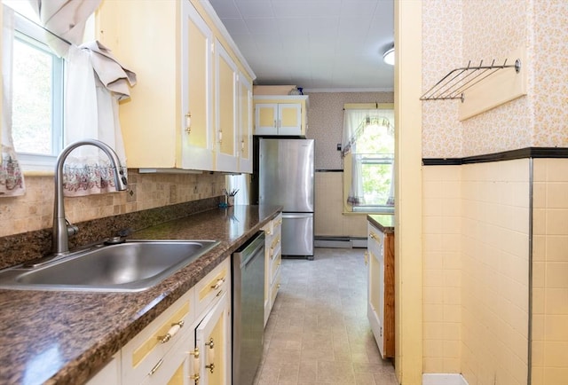 27 Stephen St, Lynn, MA 01902 - kitchen featuring a sink, stainless steel appliances, wallpapered walls, baseboard heating, and a wainscoted wall