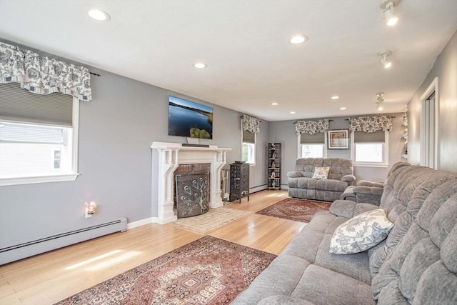 374 Forest St, Raynham, MA 02767 - living area featuring a baseboard heating unit, wood finished floors, recessed lighting, a brick fireplace, and baseboards