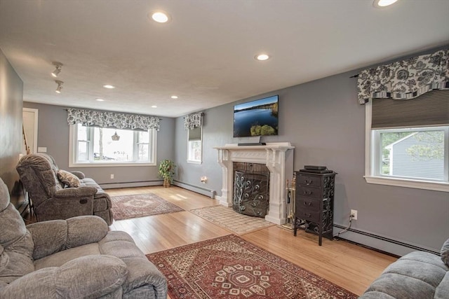 374 Forest St, Raynham, MA 02767 - living room with healthy amount of natural light, a baseboard heating unit, recessed lighting, light wood-style floors, and a fireplace