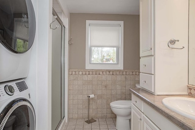 374 Forest St, Raynham, MA 02767 - full bathroom with estacked washer and dryer, vanity, tile patterned flooring, tile walls, and a shower stall