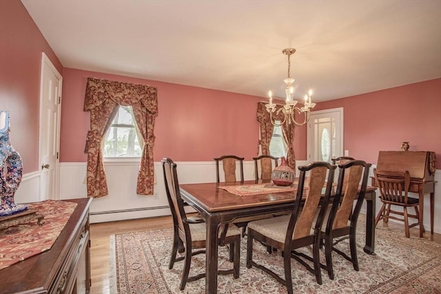 374 Forest St, Raynham, MA 02767 - dining room featuring baseboard heating, a chandelier, wainscoting, and light wood-style flooring