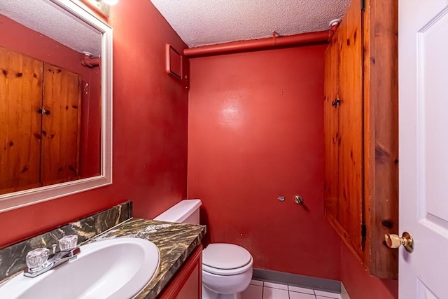 bathroom featuring tile patterned floors, vanity, toilet, and a textured ceiling