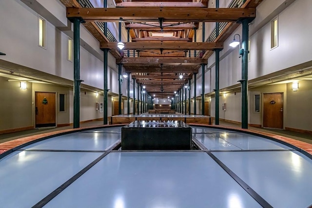 rec room with a towering ceiling, concrete floors, and a jacuzzi